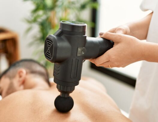 Mand der får massage med en massagepistol